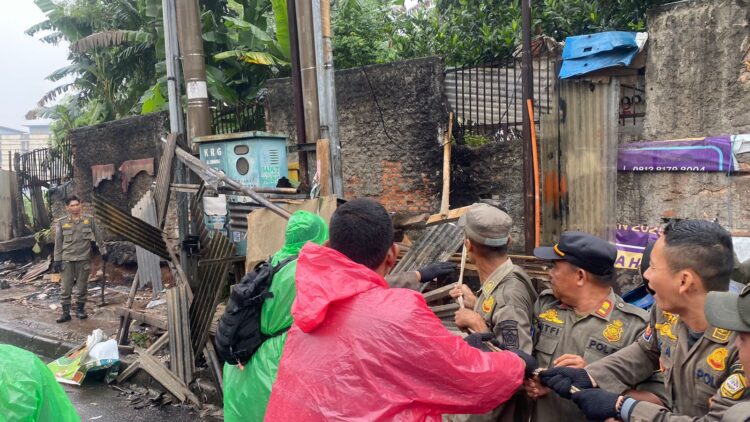 Personel Satpol PP Kabupaten Bogor saat melakukan penertiban bangunan tanpa izin di ruang publik.