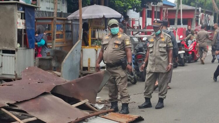 Personel Satpol PP Kabupaten Bogor saat melakukan pembongkaran lapak PKL di wilayah Dramaga secara manual.