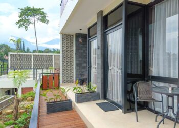 Fasilitas jacuzzi air panas di balkon Suite Cabin Mamifokobo Cipanas dengan pemandangan gunung.