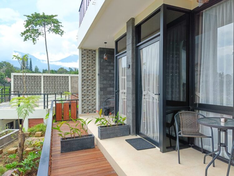 Fasilitas jacuzzi air panas di balkon Suite Cabin Mamifokobo Cipanas dengan pemandangan gunung.