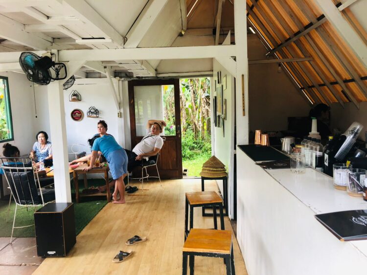 Pengunjung sedang menikmati kopi dengan latar belakang pemandangan sawah di Gardu Caffe Mulyaharja.