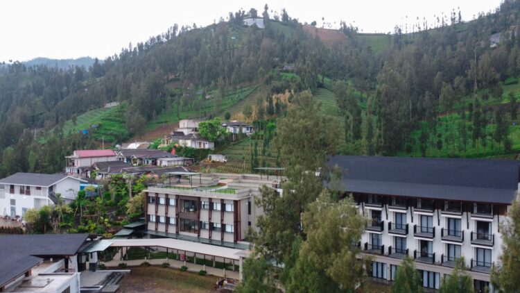 Fasad bangunan Jambuluwuk Bromo Resort & Poshtel dengan latar belakang pemandangan pegunungan yang asri.