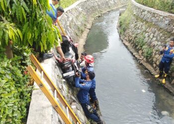 Damkar Evakuasi Sepeda Motor Masuk Kedalam Selokan di Cileungsi, Pengendara Alami Luka-luka