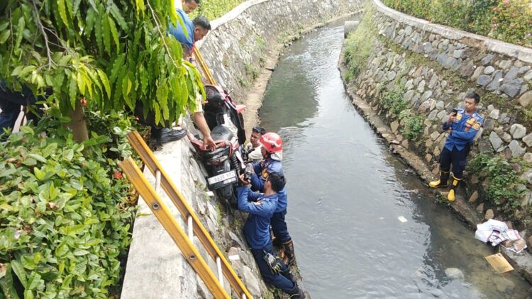 Damkar Evakuasi Sepeda Motor Masuk Kedalam Selokan di Cileungsi, Pengendara Alami Luka-luka
